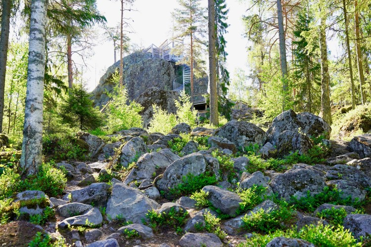 Suuri siirtolohkare metsäss, kivien ympäröimänä. 