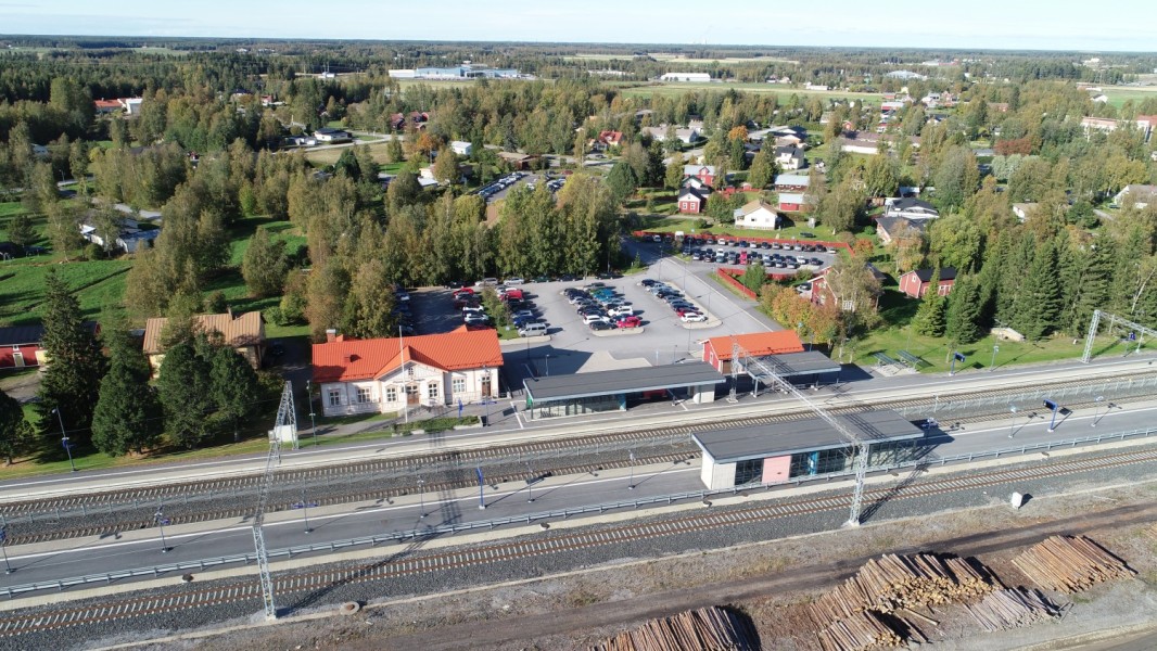 Dronekuva, jossa näkyy rautatieasema sekä sen ympäröivä alue, talot, kadut ja viheralueet.