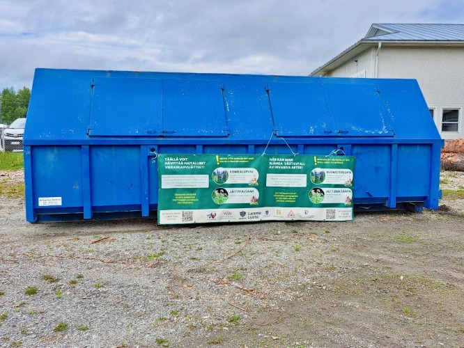 En blå container. Det hänger ett plakat med information om insamlingen på containern.