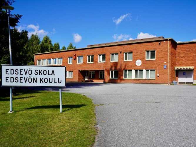 Edsevön koulu. Koulun edessä on kyltti, jossa lukee Edsevö skola - Edsevön koulu.