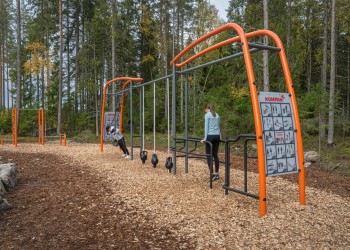 Två personer gymmar i ett utegym.