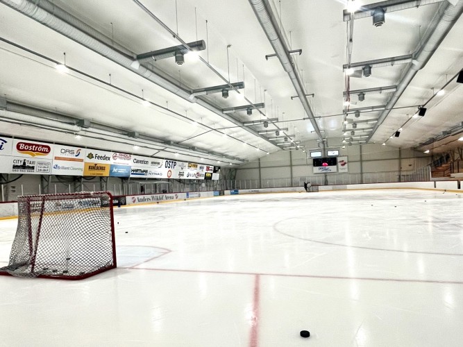 Ishallen inifrån. Isen och ett ensam hockeymål.