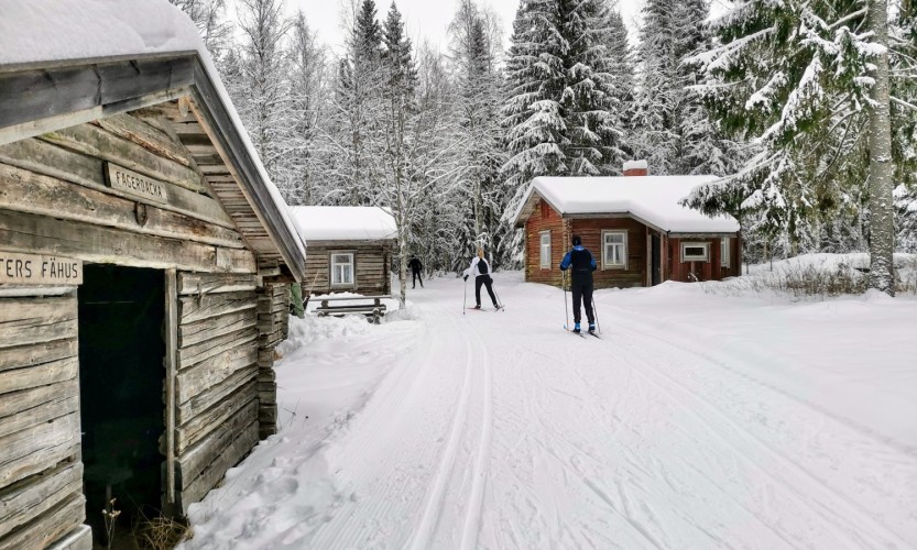 Fagerbackan karjamajakylän läpi kulkeva hiihtolatu. Kaksi hiihtäjää.