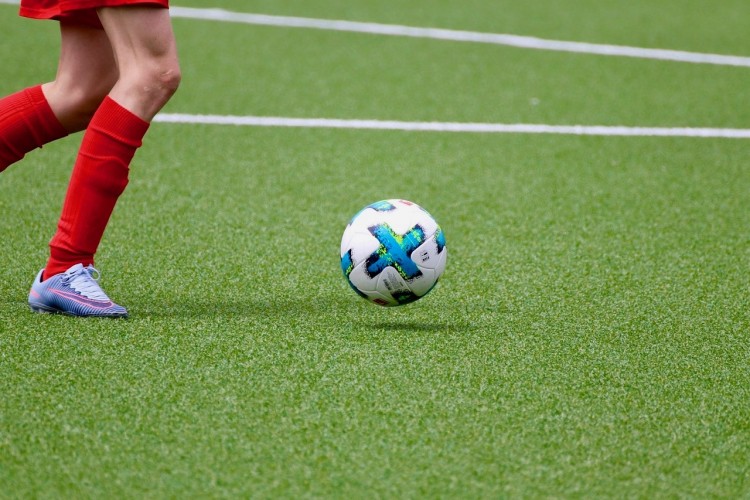 En fotboll och benen av en ung fotbollsspelare.
