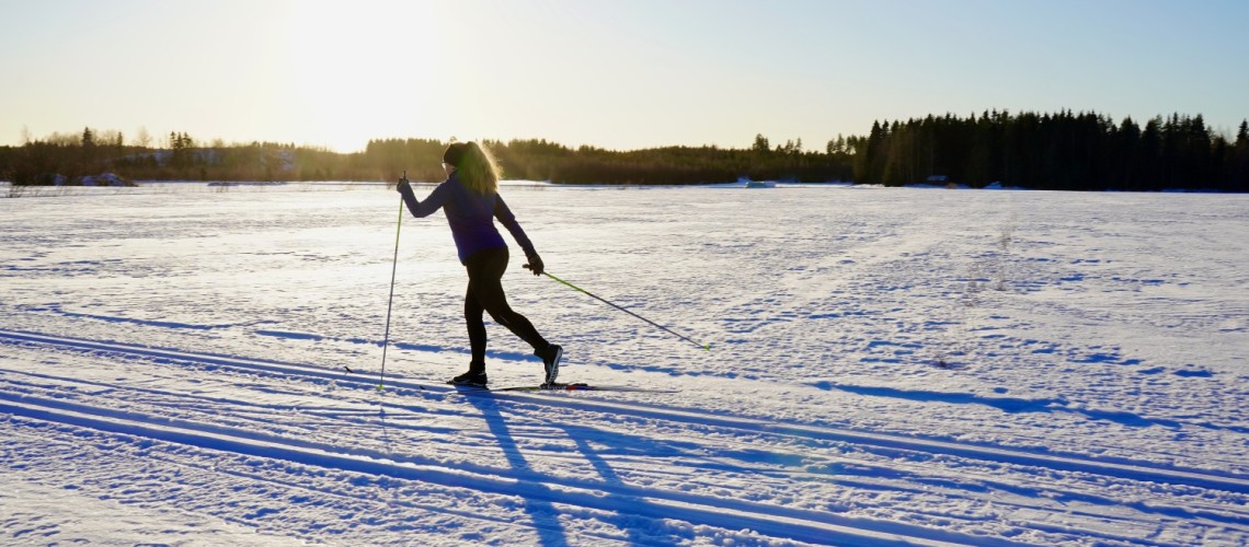 En ensam skidåkare skidar på spåret till Stortallen. Motsolsbild.