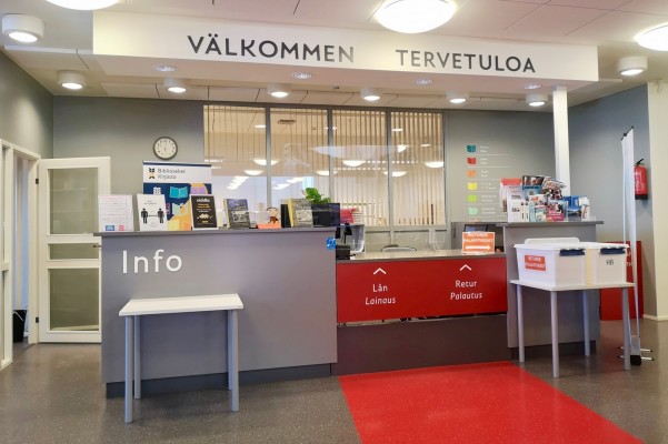 Huvudbibliotekets lånedisk. Ovanför disken står det Välkommen - Tervetuloa.