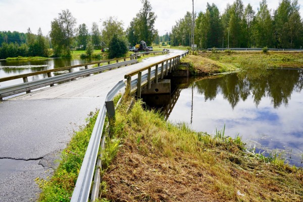 Östfolkbron fotograferad lite från sidan en regntung dag. Under bron flyter Esse å stilla.