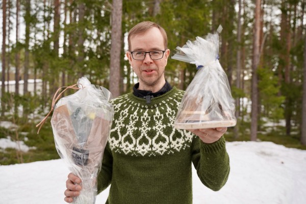 Mattias Kanckos seisoo ulkona pienen metsikön edessä . Hänellä on Pedersörekellopalkinto ja kukkia kädessään.