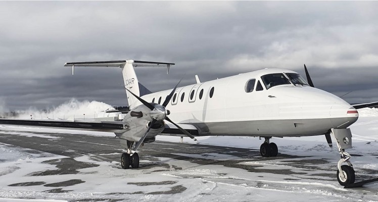 Jonairs flygplan parkerat på landningsbanan. Det är lite snö på marken.