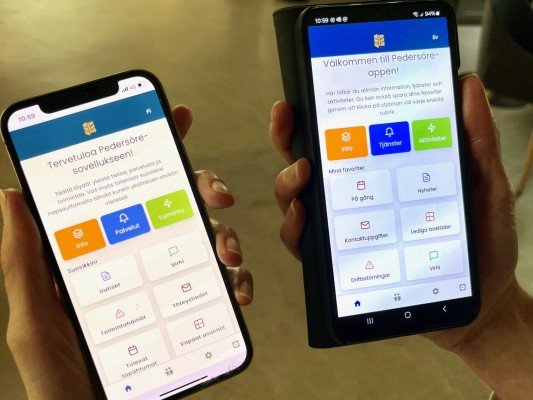 Två mobiltelefoner där Pedersöre-appen är öppen. En finsk version och en svensk version.