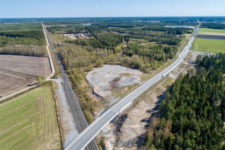 En flygbild över det ena aktuella området i markaffären. Landsvägen, järnvägen och skogsområdet.