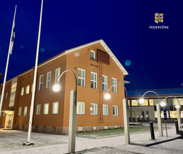 Kunnantalo aamunkoitteessa. Taivas on vielä pimeä.