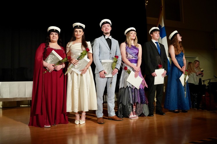 Sex festklädda ungdomar står på scenen, från vänster två flickor, en pojke, en flicka, en pojke, en flicka.