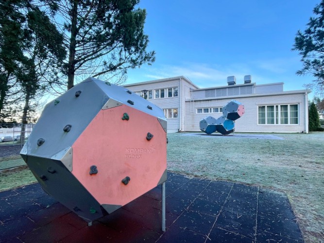 Två boulderingklot utanför Sursik skola, som syns i bakgrunden.