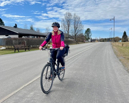 En kvinna cyklar på en cykelväg.