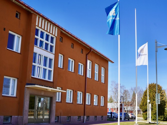 Kunnanvirastotalon vanha osa, jossa on tiilijulkisivu. Kunnan lippu on nostettu lipputankoon.