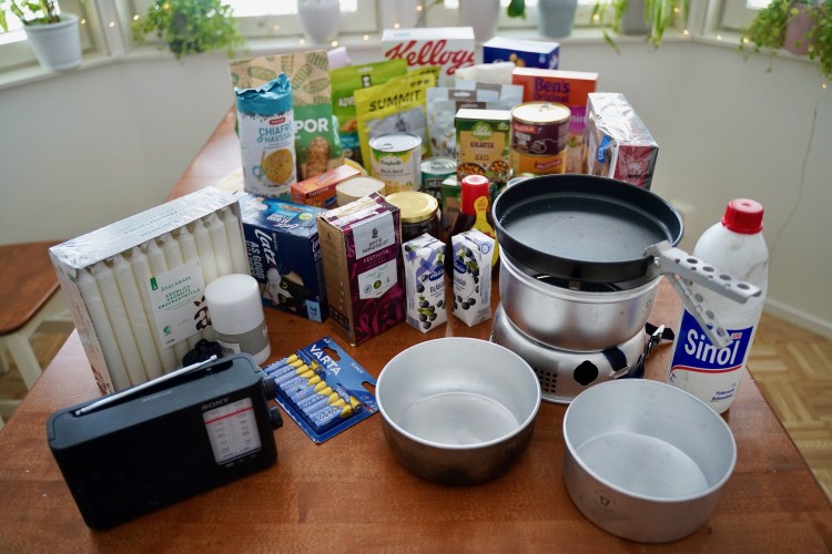 Exempel på reservförråd: Olika livsmedel, radio, ljus, stormkök mm på ett köksbord.