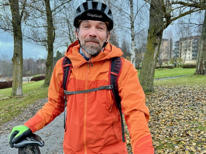 En man med cykelhjälm ler mot kameran.