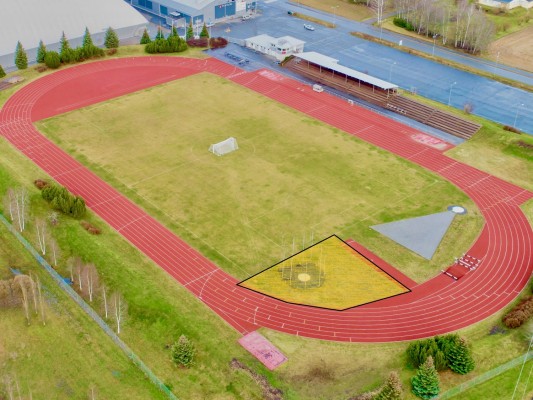 En flygbild över sportplanen, där det berörda byggområdet är utmärkt med linje och gulgrön färg.