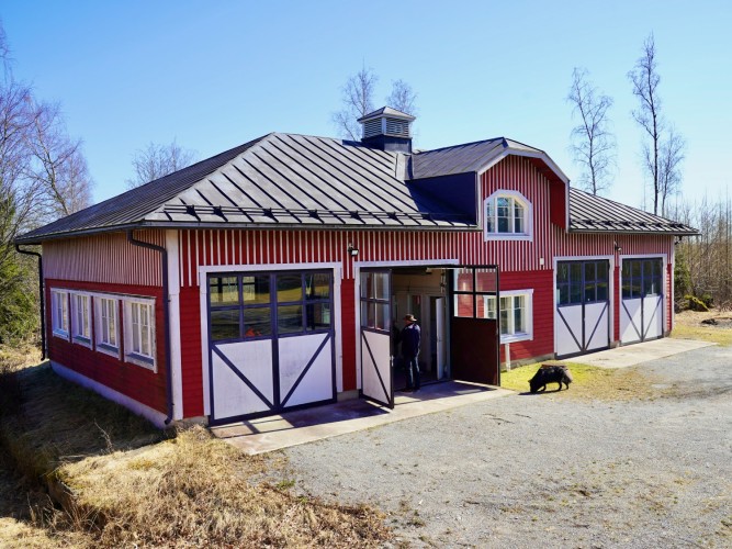 En hall i två våningar. Hallen har fyra dubbeldörrar. En dörr är öppen.