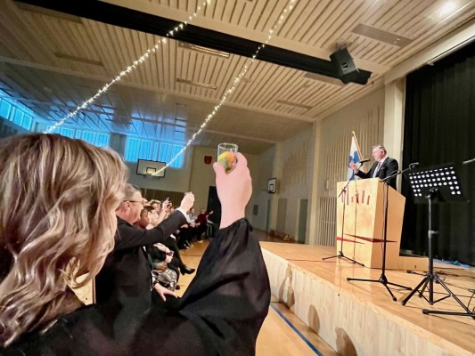 Publiken skålar med kommundirektören med glas fyllda med sötsaker.