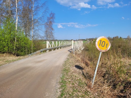 Vanha Näsibacka -silta, jolle johtaa soratie. Tien reunassa kyltti, jossa lukee numero 10 (painorajoitus).