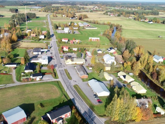 Lillby fotograferat med drönare. Landsvägen är mitt i bild, dessutom syns åkrar, hus och träd.