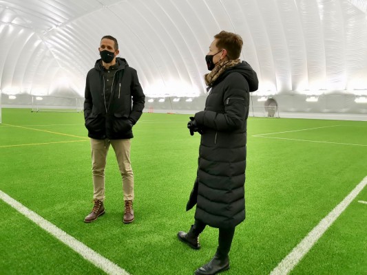 Två personer står inne i en välupplyst bollhall.