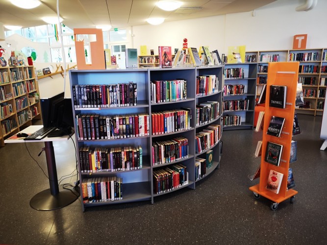 Kirjahyllyjä ja kirjoja kirjastossa.