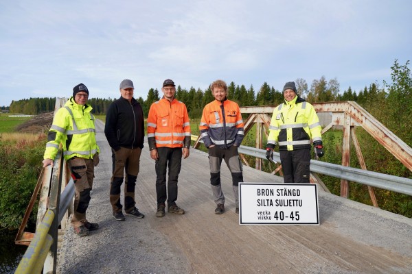 Neljä urakoitsijaa ja kunnan tiemestari seisovat Kittholm-sillalla. .