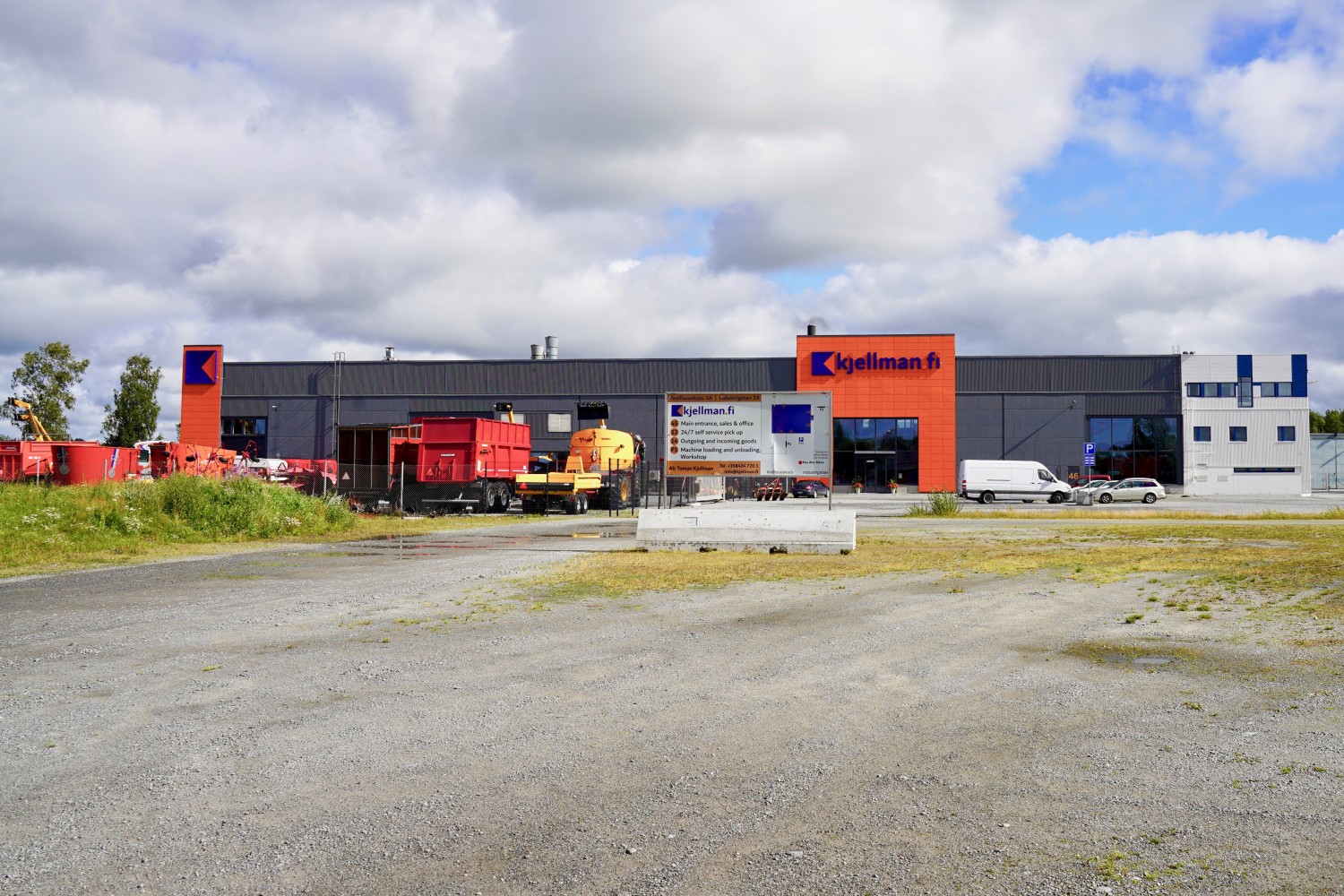 Butiksfastigheten fotograferad utifrån. Parkeringsplats framför stora dörrar.