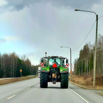 En traktor kör på en landsväg.
