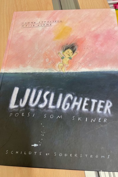 Boken Ljusligheter, poesi som skiner. En ritad figur mitt på bokens pärm.