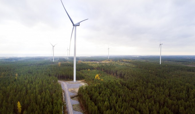 En landskapsbild med flera vindkraftsverk. Fotograferat med drönare från luften, så man ser långt.